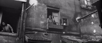 Movie still from “Shoot the Piano Player” (1960), directed by François Truffaut – A man and a woman looking out of a window; Wide shot, High angle
