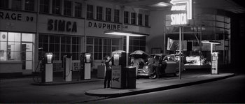 Movie still from “Shoot the Piano Player” (1960), directed by François Truffaut – A man standing in front of a gas pump; Extreme Wide shot, High angle