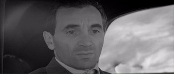 Movie still from “Shoot the Piano Player” (1960), directed by François Truffaut – Black and white photograph of a man in a business suit; Close Up shot, Low angle