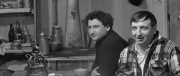 Movie still from “Shoot the Piano Player” (1960), directed by François Truffaut – A black and white photo of a man sitting in front of an oven; Medium shot, High angle