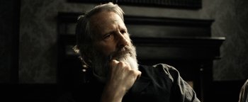 Movie still from “Godless” (2017), directed by Scott Frank – An older man with a beard is looking to his left; Close Up shot, Low angle