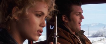 Movie still from “Showgirls” (1995), directed by Paul Verhoeven – A man and a woman in a car with a knife; Close Up shot, Over the shoulder angle