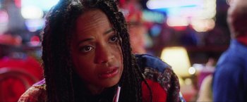 Movie still from “Showgirls” (1995), directed by Paul Verhoeven – A person with dreadlocks looking at the camera; Close Up shot, Over the shoulder angle