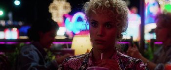 Movie still from “Showgirls” (1995), directed by Paul Verhoeven – A person holding a drink in a room; Close Up shot, Over the shoulder angle