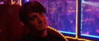 Movie still from “Showgirls” (1995), directed by Paul Verhoeven – A person wearing a black shirt; Close Up shot, Over the shoulder angle