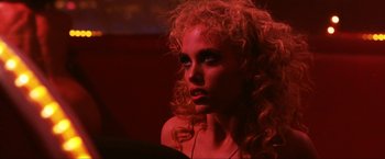 Movie still from “Showgirls” (1995), directed by Paul Verhoeven – A beautiful young woman with red curly hair and blue eyes; Close Up shot, Over the shoulder angle