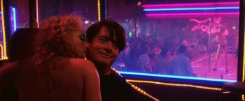 Movie still from “Showgirls” (1995), directed by Paul Verhoeven – A man and a woman are hugging in front of a crowd; Close Up shot, Low angle