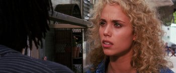 Movie still from “Showgirls” (1995), directed by Paul Verhoeven – A person with curly blonde hair; Close Up shot, Over the shoulder angle