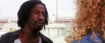 Movie still from “Showgirls” (1995), directed by Paul Verhoeven – A person with dreadlocks looking at the camera; Close Up shot, Low angle