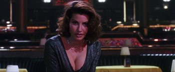 Movie still from “Showgirls” (1995), directed by Paul Verhoeven – A beautiful woman in a black top sitting in a room; Close Up shot, Low angle