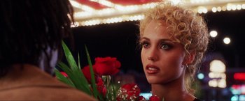 Movie still from “Showgirls” (1995), directed by Paul Verhoeven – A person holding a bouquet of roses; Close Up shot, Over the shoulder angle