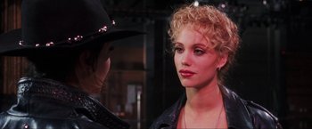 Movie still from “Showgirls” (1995), directed by Paul Verhoeven – A woman in a cowboy hat talking to another woman; Close Up shot, Over the shoulder angle