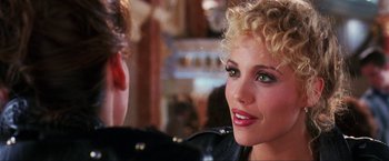 Movie still from “Showgirls” (1995), directed by Paul Verhoeven – A person with curly blonde hair; Close Up shot, Over the shoulder angle