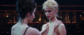 Movie still from “Showgirls” (1995), directed by Paul Verhoeven – Two women one of whom is wearing a necklace and one of whom is wearing a ring; Close Up shot, Over the shoulder angle