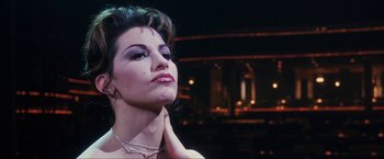 Movie still from “Showgirls” (1995), directed by Paul Verhoeven – A person wearing a necklace; Close Up shot, Low angle