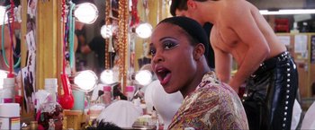 Movie still from “Showgirls” (1995), directed by Paul Verhoeven – A woman with her mouth wide open in front of a mirror; Close Up shot, Over the shoulder angle