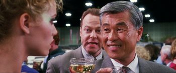 Movie still from “Showgirls” (1995), directed by Paul Verhoeven – A group of people that are sitting around a table; Close Up shot, Over the shoulder angle