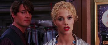 Movie still from “Showgirls” (1995), directed by Paul Verhoeven – A woman with blonde curly hair wearing a necklace; Close Up shot, Over the shoulder angle