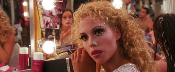 Movie still from “Showgirls” (1995), directed by Paul Verhoeven – A person with a make - up on; Close Up shot, Over the shoulder angle