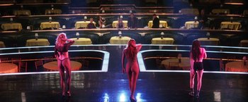 Movie still from “Showgirls” (1995), directed by Paul Verhoeven – A woman in a red bodysuit walks in front of an audience; Extreme Wide shot, High angle