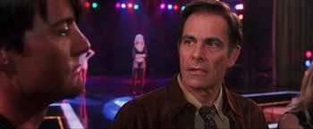 Movie still from “Showgirls” (1995), directed by Paul Verhoeven – A man standing in front of a group of women; Close Up shot, Over the shoulder angle