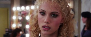 Movie still from “Showgirls” (1995), directed by Paul Verhoeven – A person with curly hair; Close Up shot, Over the shoulder angle