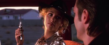 Movie still from “Showgirls” (1995), directed by Paul Verhoeven – A woman in a cowboy hat sitting in a car; Close Up shot, Over the shoulder angle