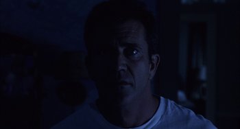 Movie still from “Signs” (2002), directed by M. Night Shyamalan – A person wearing a white t - shirt; Close Up shot, Low angle