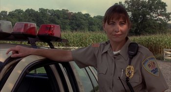 Movie still from “Signs” (2002), directed by M. Night Shyamalan – A female police officer sitting in a car; Close Up shot, Low angle
