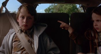 Movie still from “Signs” (2002), directed by M. Night Shyamalan – Two children in the back seat of a car; Close Up shot, Over the shoulder angle