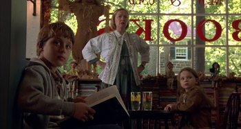 Movie still from “Signs” (2002), directed by M. Night Shyamalan – A woman and two children are sitting in front of a window; Medium shot, Low angle