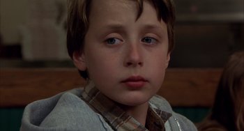 Movie still from “Signs” (2002), directed by M. Night Shyamalan – A young boy's face looking at the camera; Close Up shot, Low angle