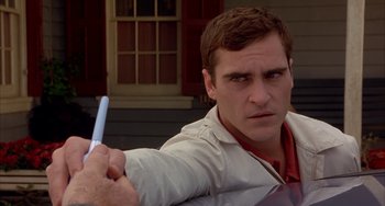 Movie still from “Signs” (2002), directed by M. Night Shyamalan – A person holding a pen; Close Up shot, Over the shoulder angle