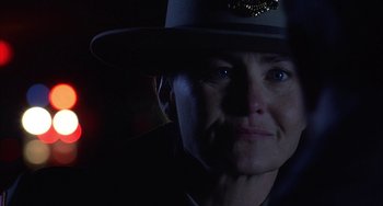 Movie still from “Signs” (2002), directed by M. Night Shyamalan – A woman wearing a police uniform and a hat; Close Up shot, Over the shoulder angle