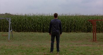 Movie still from “Signs” (2002), directed by M. Night Shyamalan – A man standing in front of a field of corn; Extreme Wide shot, Over the shoulder angle