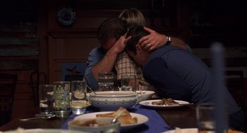 Movie still from “Signs” (2002), directed by M. Night Shyamalan – A couple of people sitting at a dinner table with food; Medium shot, High angle