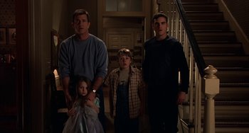 Movie still from “Signs” (2002), directed by M. Night Shyamalan – Two men and two children standing in a room; Medium shot, Low angle