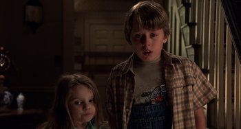 Movie still from “Signs” (2002), directed by M. Night Shyamalan – A boy and a little girl standing next to each other; Medium shot, Low angle