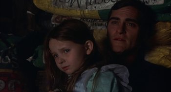 Movie still from “Signs” (2002), directed by M. Night Shyamalan – A man and a little girl sitting next to each other; Close Up shot, Low angle