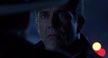 Movie still from “Signs” (2002), directed by M. Night Shyamalan – An older man stares into the camera in the dark; Close Up shot, Over the shoulder angle