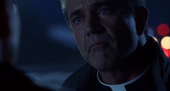 Movie still from “Signs” (2002), directed by M. Night Shyamalan – A person wearing a white shirt; Close Up shot, Low angle