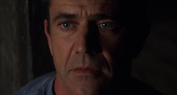 Movie still from “Signs” (2002), directed by M. Night Shyamalan – A person's face in the dark; Close Up shot, Low angle