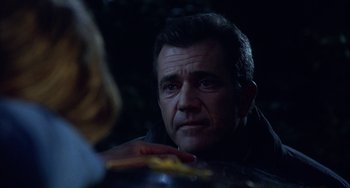 Movie still from “Signs” (2002), directed by M. Night Shyamalan – A person sitting at a table; Close Up shot, Over the shoulder angle