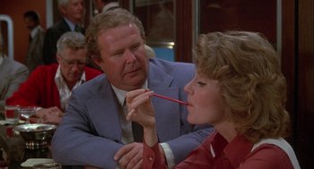 Movie still from “Silver Streak” (1976), directed by Arthur Hiller – An older man and a young woman are playing with a red pencil; Close Up shot, Over the shoulder angle