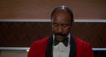 Movie still from “Silver Streak” (1976), directed by Arthur Hiller – A man in a red jacket and a black bow tie; Close Up shot, Low angle