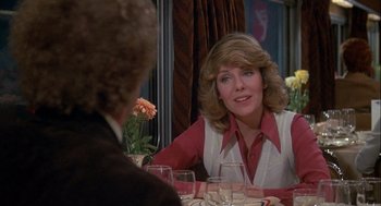 Movie still from “Silver Streak” (1976), directed by Arthur Hiller – A woman sitting at a dinner table with a man; Medium shot, Over the shoulder angle