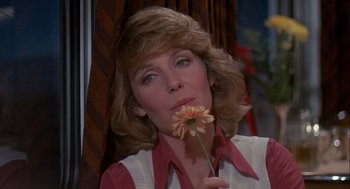 Movie still from “Silver Streak” (1976), directed by Arthur Hiller – A person holding a flower in her mouth; Close Up shot, Low angle