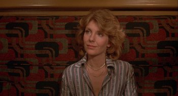 Movie still from “Silver Streak” (1976), directed by Arthur Hiller – A woman sitting on a couch in front of a wall; Close Up shot, Low angle