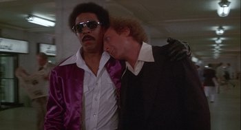 Movie still from “Silver Streak” (1976), directed by Arthur Hiller – A couple of men standing next to each other; Medium shot, Low angle