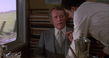 Movie still from “Silver Streak” (1976), directed by Arthur Hiller – A man in a suit and tie looking at another man in a white shirt; Medium shot, Over the shoulder angle